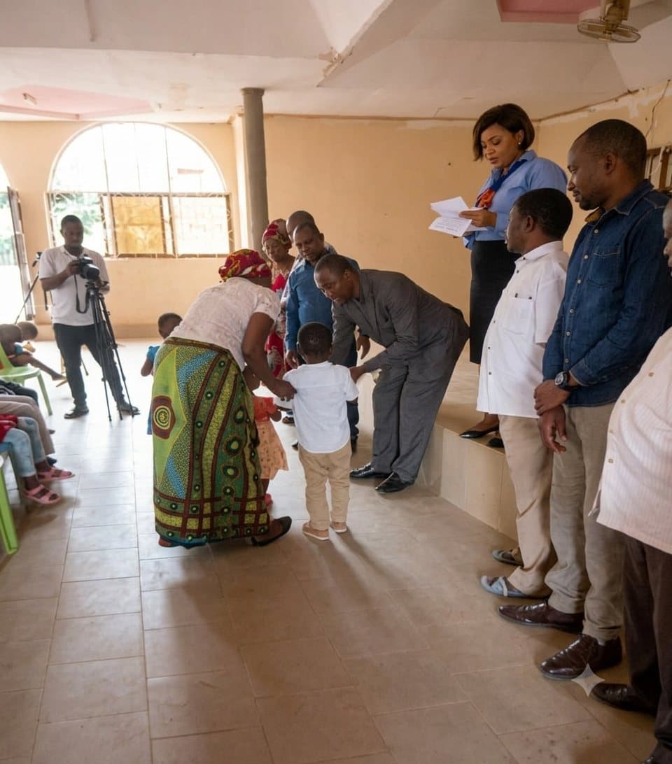 A child receiving a birth certificate at a UPSDE handover, supported by community members and officials