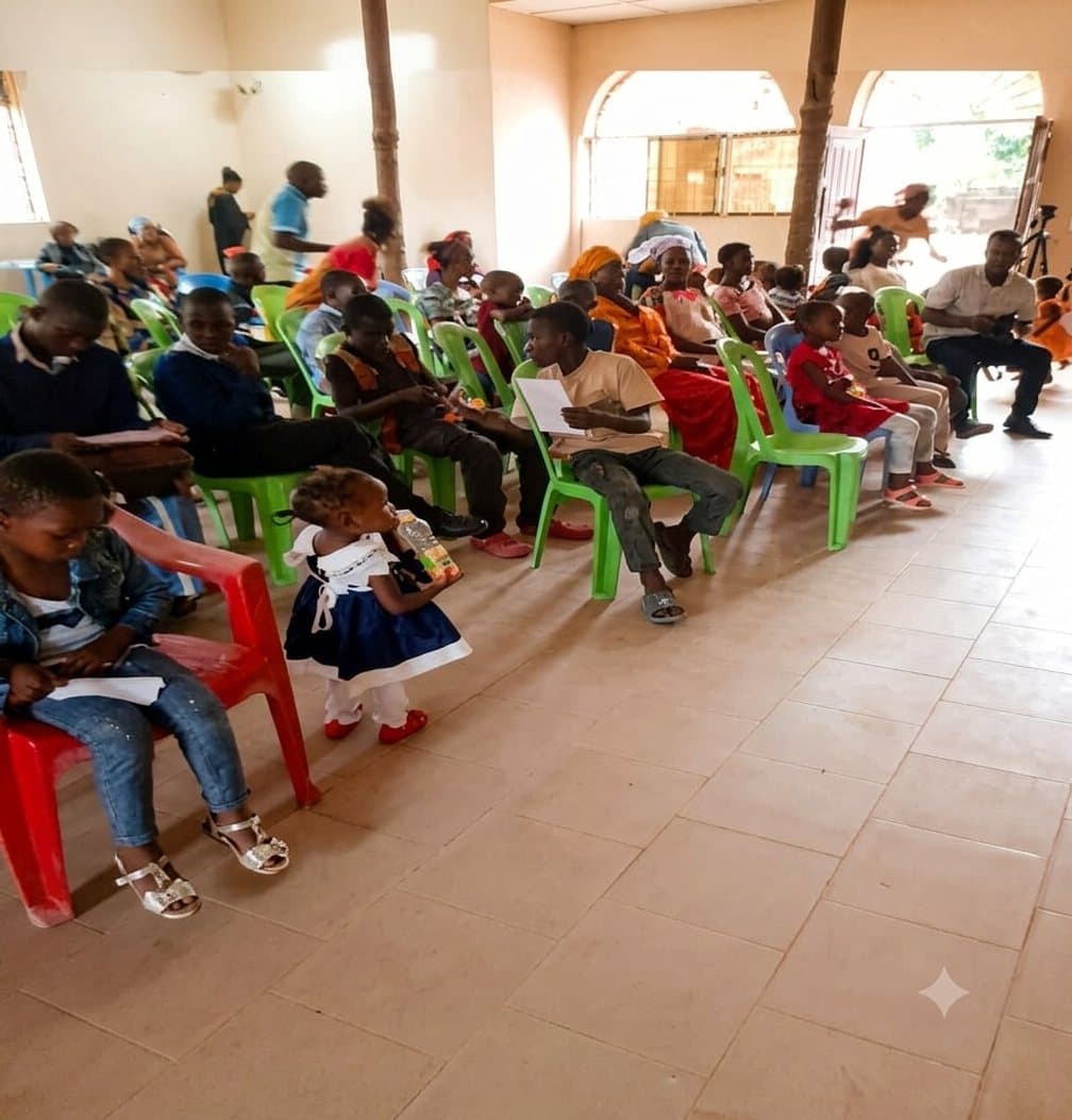 Children and families seated together during a UPSDE community gathering in a hall