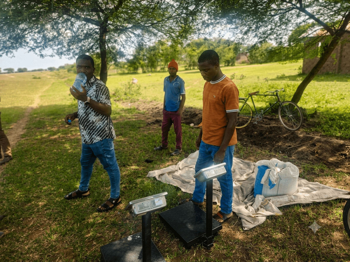 UPSDE trainee technicians standing with weighing scales during outdoor field training